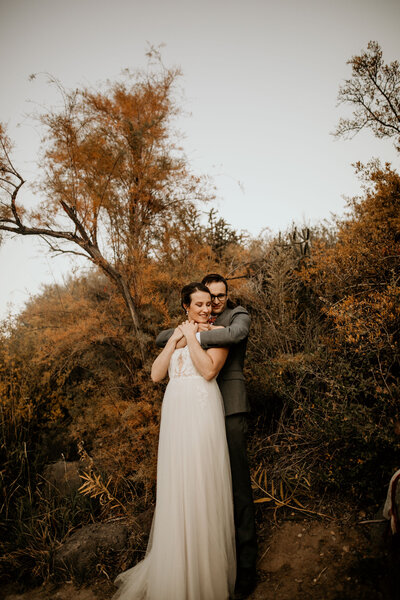 husband hugging new wife from behind in Taos