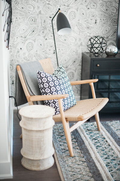 cane arm chair with wood garden stool black and white floral pillow malochite black and white wallpaper
