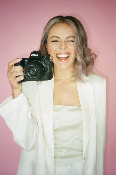 woman with camera smiles