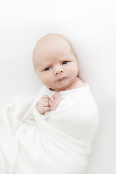 Newborn baby looking directly into the camera on a photoshoot