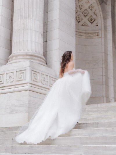 bride running up the stairs at the new york public library