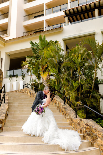 Bride and Groom kissing while standing in the middle of staircase