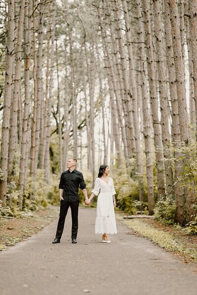 Bride and groom strolling hand-in-hand through a forest of birch trees