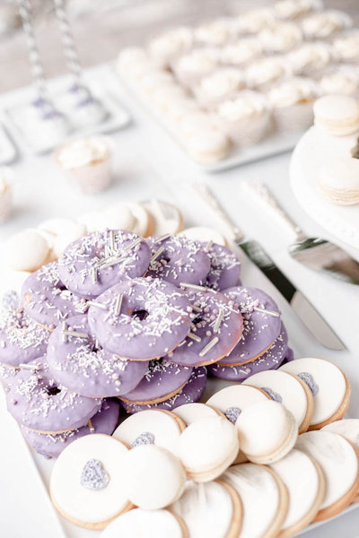 sweet table with purple decorated donuts