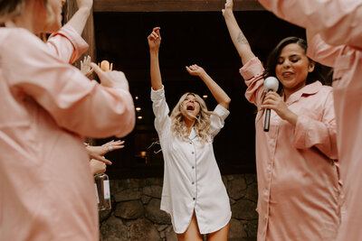 bride dancing with her bridesmaids while getting ready