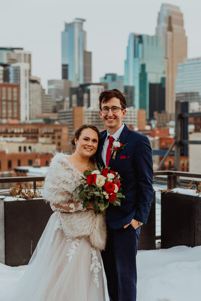 bride and groom portrait with minneapolis skyline behind them