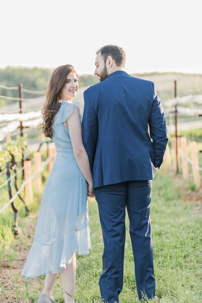 engaged couple embracing in vineyard
