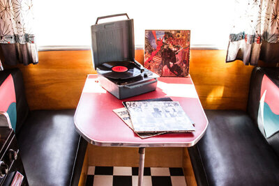 Destination Branding interior mini airstream black white checkered floor between breakfast booth with portable record player on table
