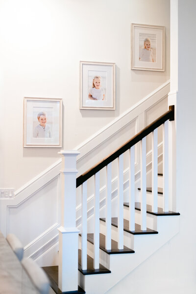 beautiful home stairway with heirloom gallery wall of family portraits