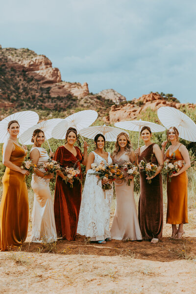 bride and bridesmaids stand with parasols in sedona arizona