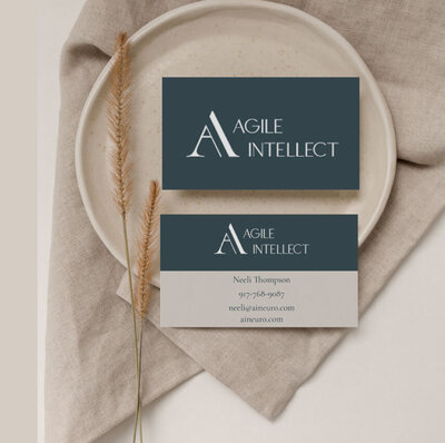 Business cards for Agile Intellect flatlay on a tan background