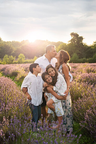 A family of 5 cuddling during a sunset photo shoot at Mayfield Lavender farm in Surrey