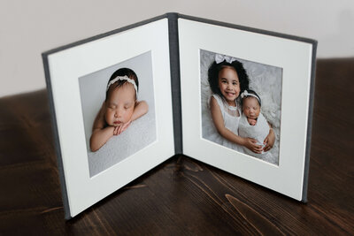 two  matted printed photos displayed in a bifold grey folio