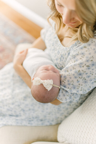 A photo of a new mother holding her newborn baby girl during photo session with Boston newborn photographer Corinne Isabelle
