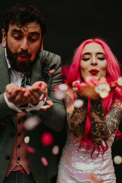 A couple blow confetti at their wedding in Manchester.
