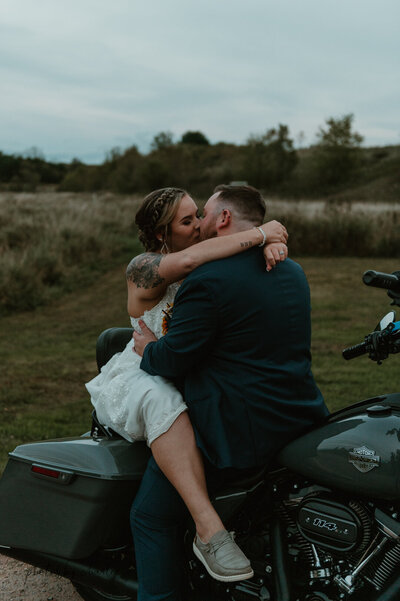 newlyweds kissing on a motorbike