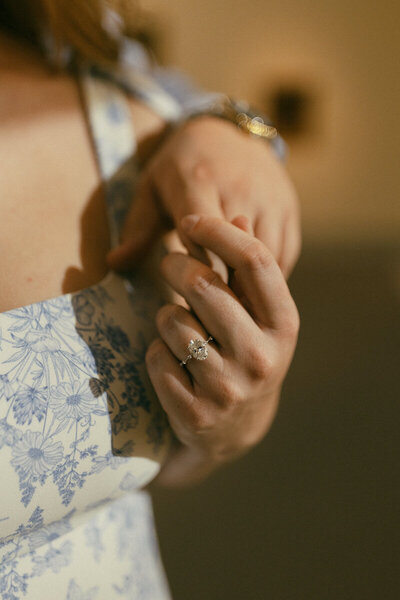 bride and groom holding hands engagement ring