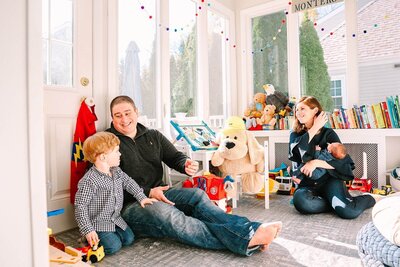 A family shares a joyful moment in a sunlit playroom, filled with toys and laughter.