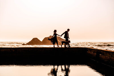 Woman and Man walking by beach at sunset