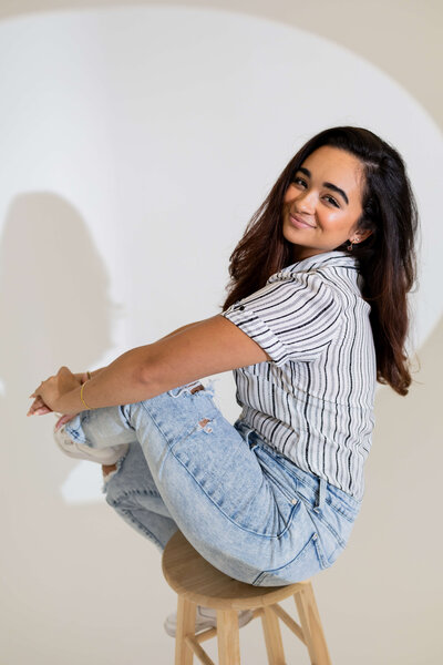 Woman photographer at Florida Social Butterfly sitting on a stool in stripped shirt