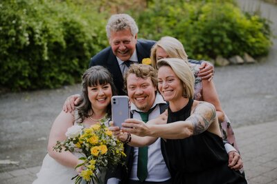 group of people taking selfie at wedding