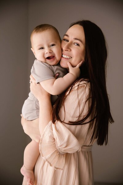 A mother holds her baby during a studio photoshoot in aimee kelly's photography studio in new plymouth