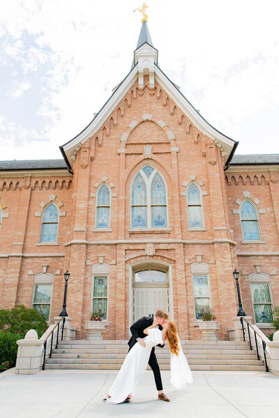 Groom dipping bride and kissing in front of the LDS Provo City Center temple