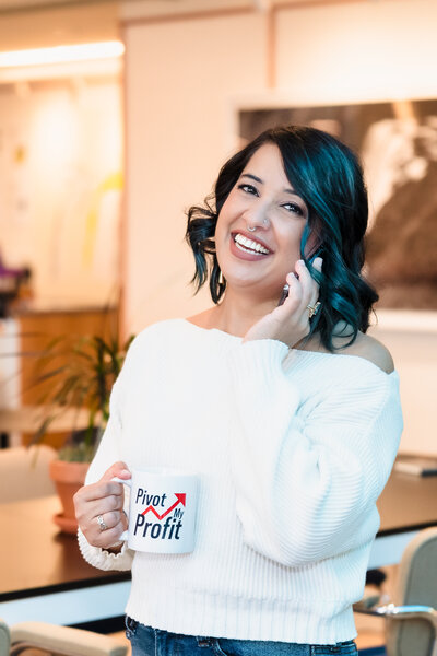 brand photo of a business coach posing with her phone and on-brand coffee mug