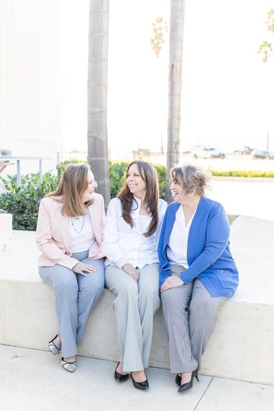 Circe Solutions owners, Connie, Tracy Narvet, and Colette Martin, sitting in front of San Diego County Courthouse.
