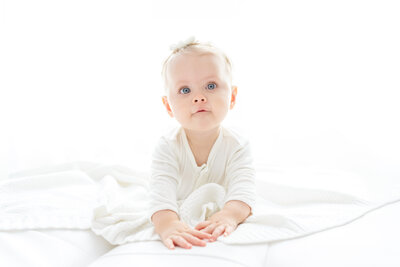 Baby and child photographer in Chandler, AZ tummy time with baby with big blue eyes
