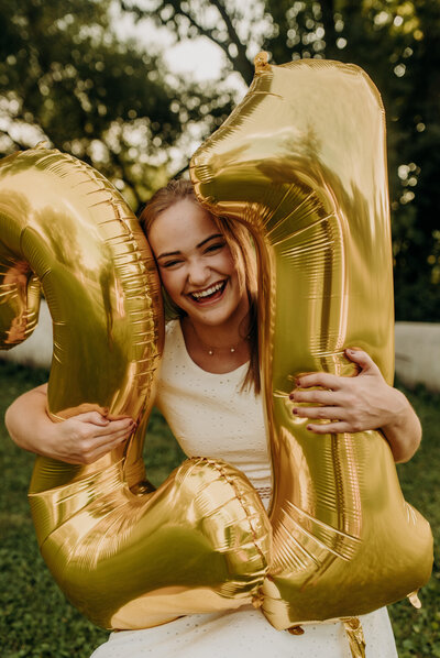 girl holding balloons and smiling at camera
