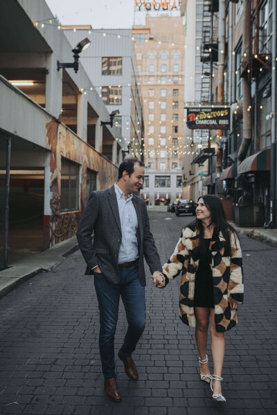 A couple holds hands and walks down an alley in downtown Memphis.