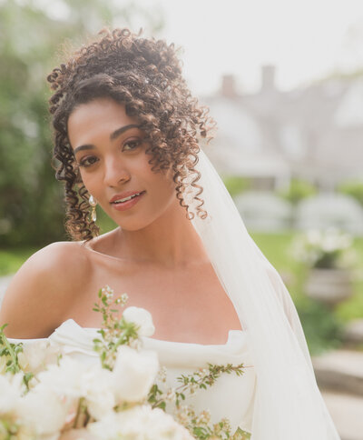 black bride and person of color wedding holding flowers.