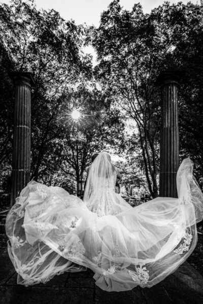 black and white photo of bride's dress blowing in the wind at the cleveland cultural gardens in downtown cleveland