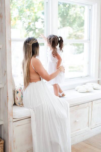 mother and daughter looking out the window maternity and family session by Miami lifestyle photographers David and Meivys of MSP Photography