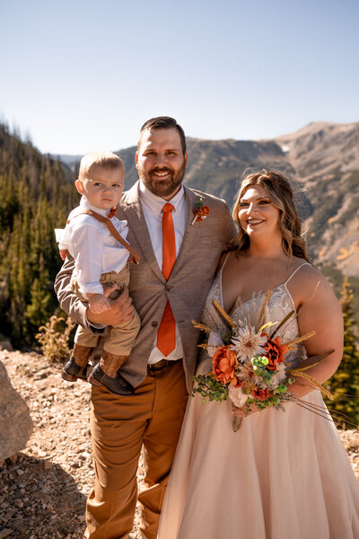 bride groom and son on their wedding day standing on the beartooth pass in montana