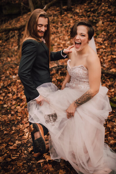 Couple laughs at muddy shoe print during Wisconsin elopement