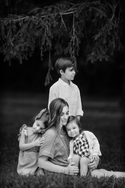 Mom with her three kids hugging for photos at Veterans Park in Hamilton, New Jersey.