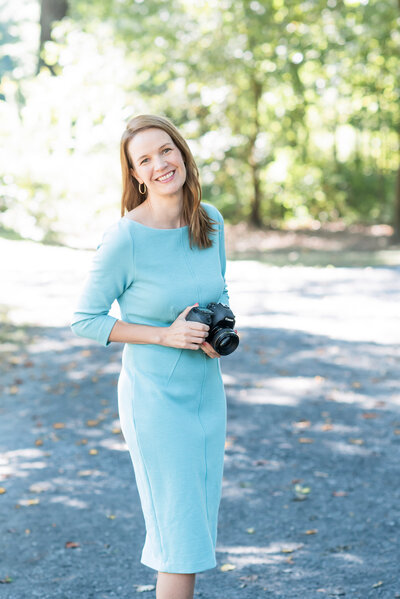 Chattanooga photographer holding a camera wearing a blue dress