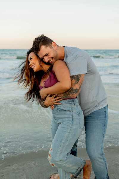 couple on beach hugging