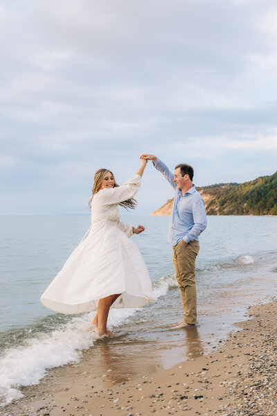 Engaged couple dancing on the beach in West Michigan