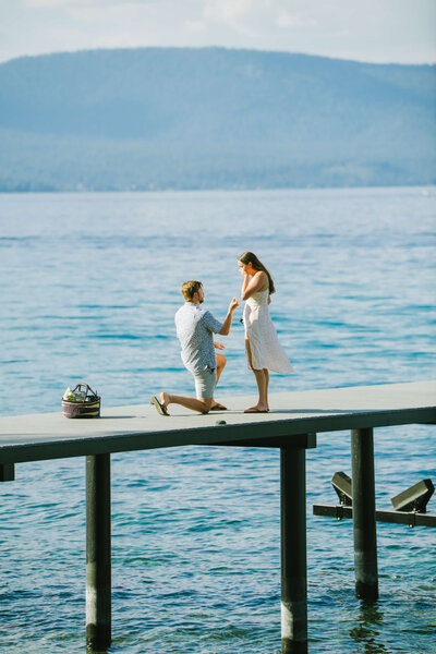 Proposal happening on the dock of family residence in Lake Tahoe on a sunny morning. 