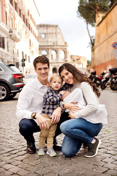 A couple with their one year old son and 4 month old baby in front of the Colosseum. Taken by Rome Family Photographer, Tricia Anne Photography