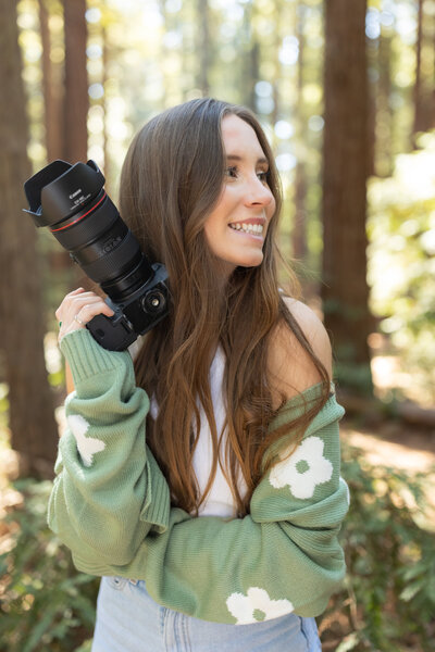 woman smiling while holding a camera