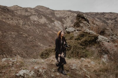 Tashina Narelle stands on a hill in Queenstown after a styled shoot