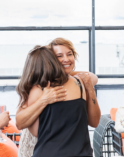 Two women hugging each other at a corporate event