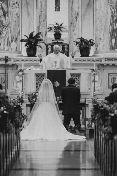 bride and groom at the altar while priests speaks