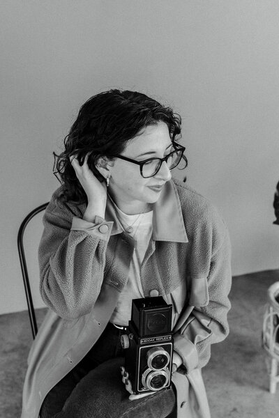 Portrait of Emily D'Angola holding vintage film camera