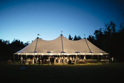 Wedding reception tent at dusk in Fields and Pond on Vashon Island.