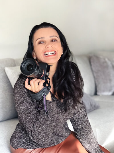 brand photographer  poses with camera in her hands
